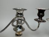 a silver candle holder with two candles on it