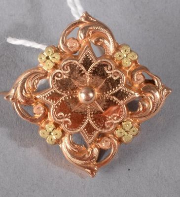 une photo d'une broche en or suspendue à un cordon blanc