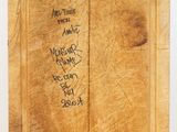 a wooden cutting board with writing on it on a table