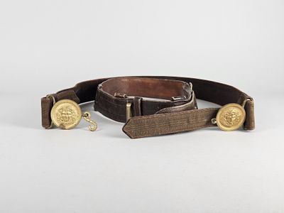 un gros plan sur une ceinture marron ornée de boutons dorés