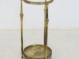 a brass plated side table with two legs and a glass top