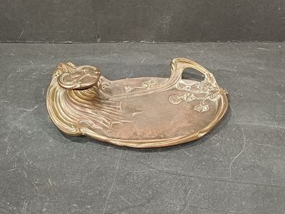 a gold plate with a bird on it sitting on a table