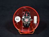 a watch in a red case on a black surface