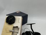 an image of a fishing reel and a box on a white surface