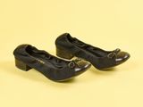 une paire de chaussures noires pour femme ornées de nœuds, sur fond jaune