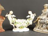 trois figurines représentant des femmes, un homme à cheval et un oiseau