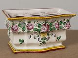 a white vase with a flower design on it