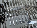 many spoons and forks laid out on a table