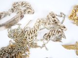 a lot of silver and gold jewelry on a white surface