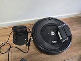 une photo montrant un « roombake » et un chargeur posés sur un parquet