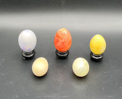 four different colored marble balls sit on top of a black surface