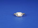 une bague ovale sertie d'une perle et de diamants sur fond bleu