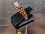une bague en or sertie d'une pierre blanche, montée sur un bijou noir