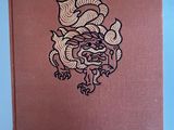 a brown book with a dragon on it on a blue surface
