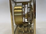 a gold clock that is sitting in a glass case