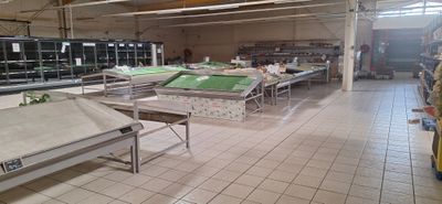 une grande salle équipée de tables et de bancs