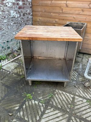 une table et une chaise sur une terrasse bordée d'un mur en briques