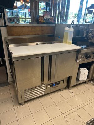 un plan de travail en acier inoxydable au milieu d'une cuisine
