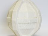 a white vase with a face on it on a white surface