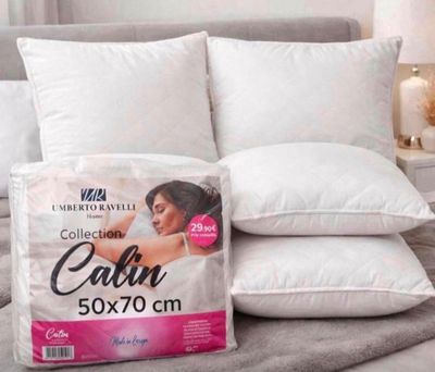 deux oreillers sur un lit, sur lequel est posée une boîte d'oreillers