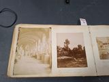 une vieille photo représentant un livre ouvert posé sur une table, avec des images de bâtiments