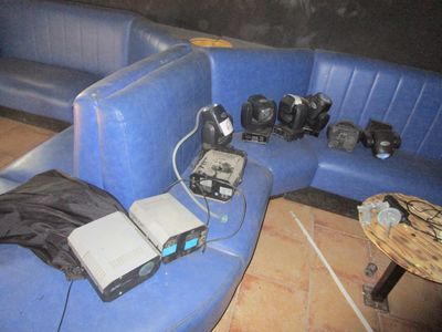 a blue couch with a laptop and other electronics on top of it