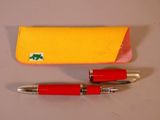 un stylo rouge et un étui jaune posés sur une table
