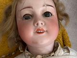 a close up of a doll laying on a yellow blanket