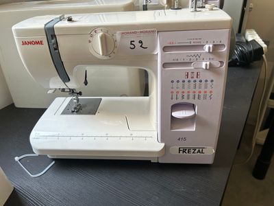 a white sewing machine sitting on a table in a room