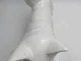 a white ceramic sculpture of a dog head on a wall