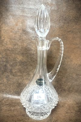 un pichet en verre transparent muni d'une anse, posé sur une table