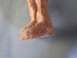 a wooden statue of a man and a woman on a rock