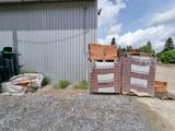 un tas de cartons et de palettes devant un bâtiment