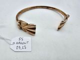 a close up of a gold bracelet with a tag on it