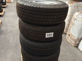 several tires stacked on pallets in a warehouse with pallets of other tires