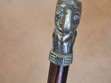 a close up of a walking stick with a statue on top of it