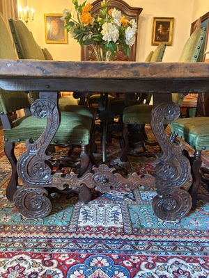 une table avec des chaises et un vase de fleurs posé dessus