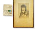 an old photograph of a woman holding a cat next to a piece of paper