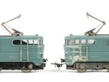 two green trains sitting side by side on a white surface