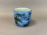 a blue and white cup sitting on top of a table