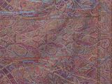 a close up of a purple and red rug with a bird on it