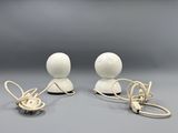 two white ceramic figurines with wires and wires attached to them