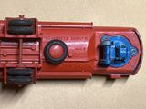 un petit camion rouge en plastique posé sur une table