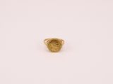 gros plan d'une bague en or sur une surface blanche