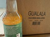 a bottle of gulala sitting on the floor next to a cardboard box