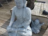a statue of a buddha sitting on a wooden deck