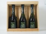 trois bouteilles de vin dans un coffret en bois sur une table