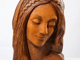 sculpture représentant la tête d'une femme aux cheveux longs et tressés