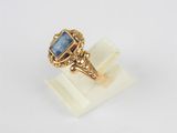 an image of a gold ring with a blue stone in it