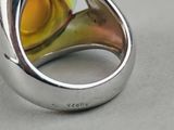a silver ring with a yellow glass in it
